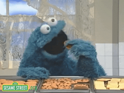 Cookie Monster gleefully eating a pile of cookies